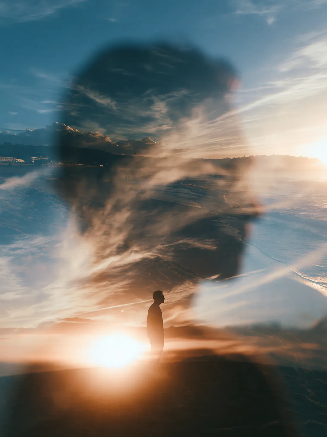 A double-exposure portrait blending into a warm island sunset