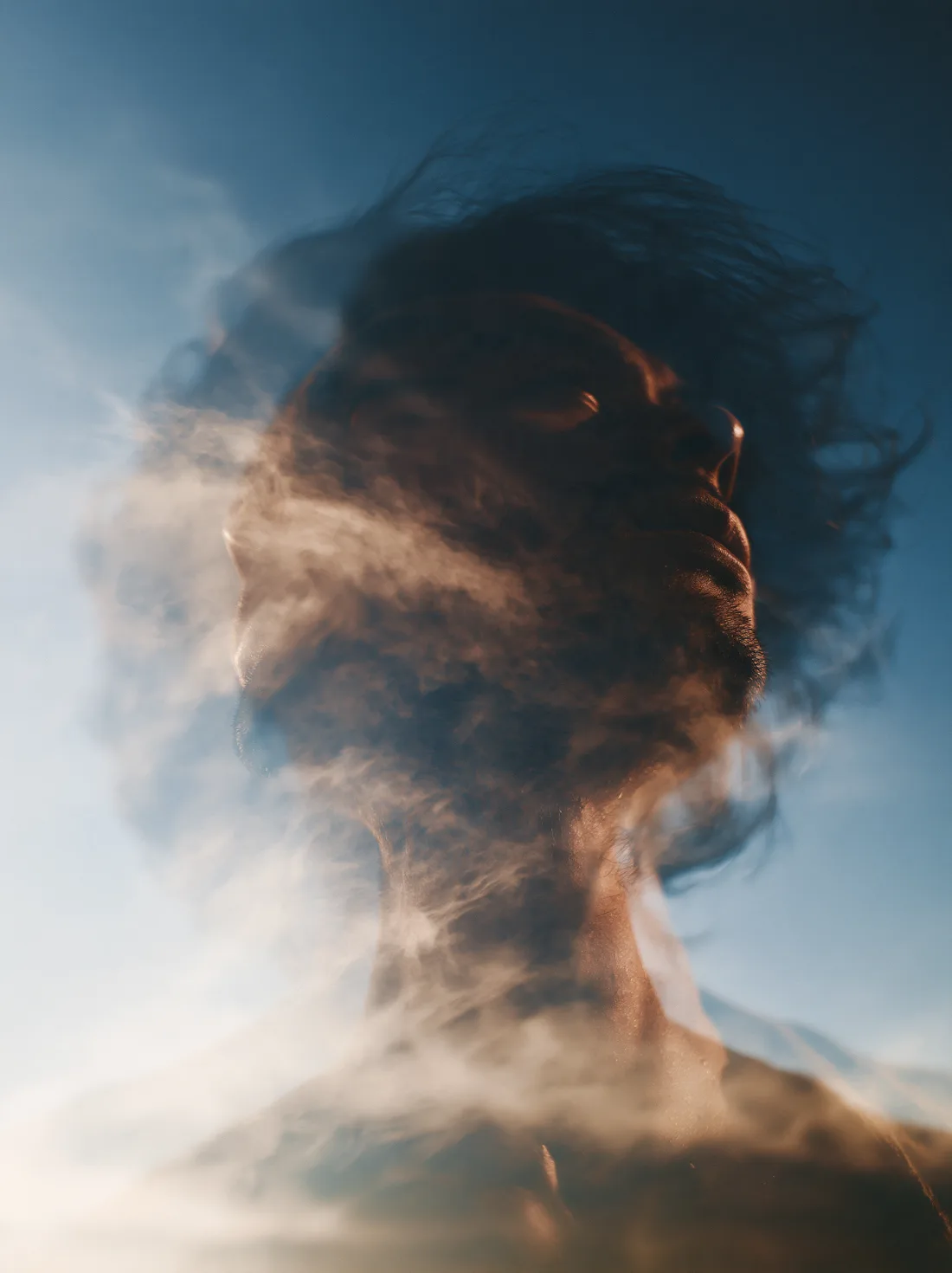 A peaceful face merging with soft clouds and the evening sky